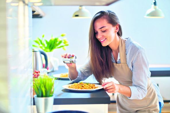 stockphotosmilinghappyjoyfulcutecookingwomanhousewifesaltsandpreparesafoodfordinner1846761622.jpg
