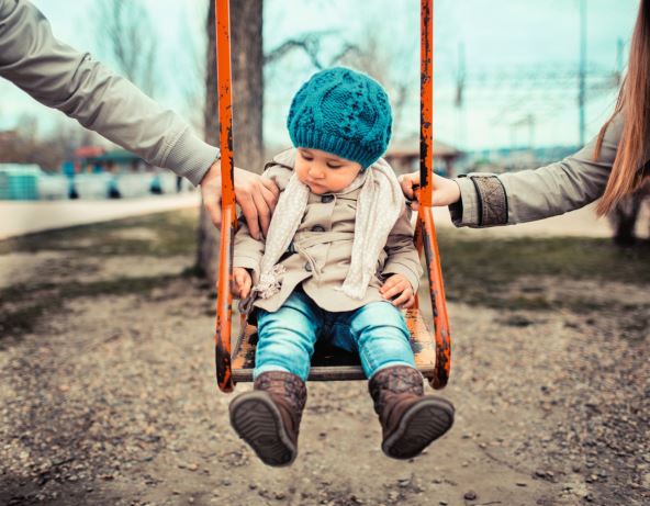 glavna--stockphotosadchildonaswinginbetweenherdivorcedparentsholdingherseparately132049541.jpg