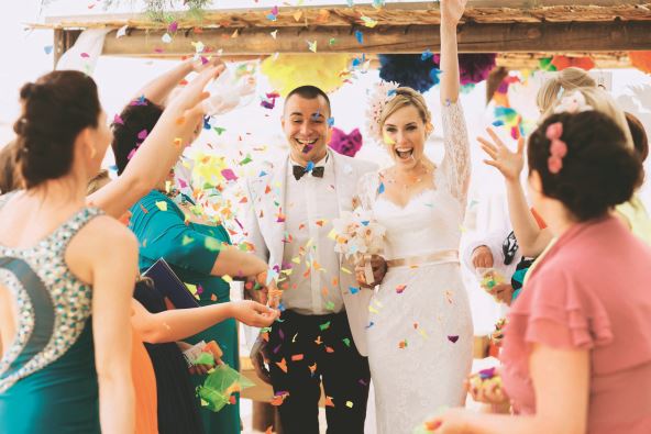 stock-photo-beautiful-gorgeous-blonde-bride-and-stylish-groom-under-confetti-hawai-colorful-sand-ceremony-290324549.jpg